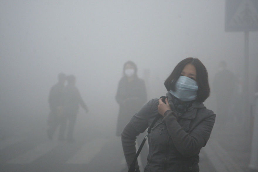 Une jeune fille traverse le smog à Beijing, où la pollution par les petites particules dépasse de 40 fois les normes internationales de sécurité